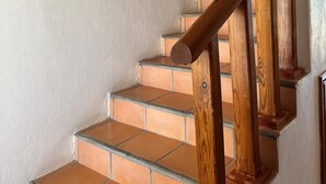 A staircase with wooden handrails and terracotta tiles. - Paradise Villa #5 | Oceanfront Escape at Playa Encanto (Puerto Peñasco)