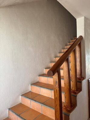 A staircase with wooden handrails and terracotta tiles. - Paradise Villa #5 | Oceanfront Escape at Playa Encanto (Puerto Peñasco)