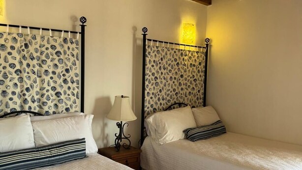 Two single beds with patterned headboards, a ceiling fan, and a nightstand with a lamp. - Paradise Villa #5 | Oceanfront Escape at Playa Encanto (Puerto Peñasco)