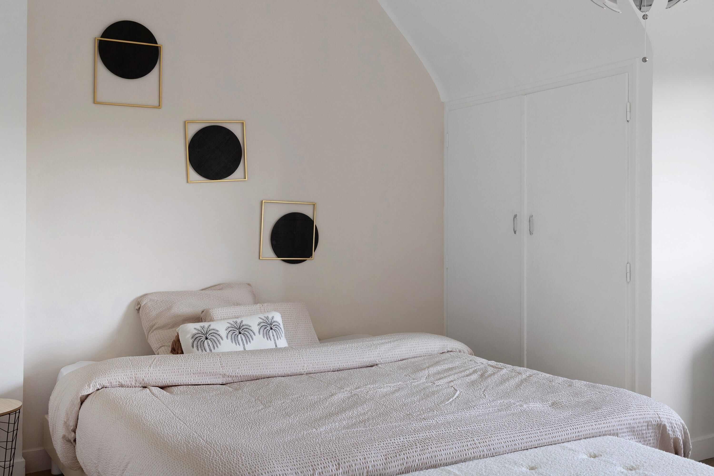A bedroom with a bed, a nightstand, and a wardrobe.