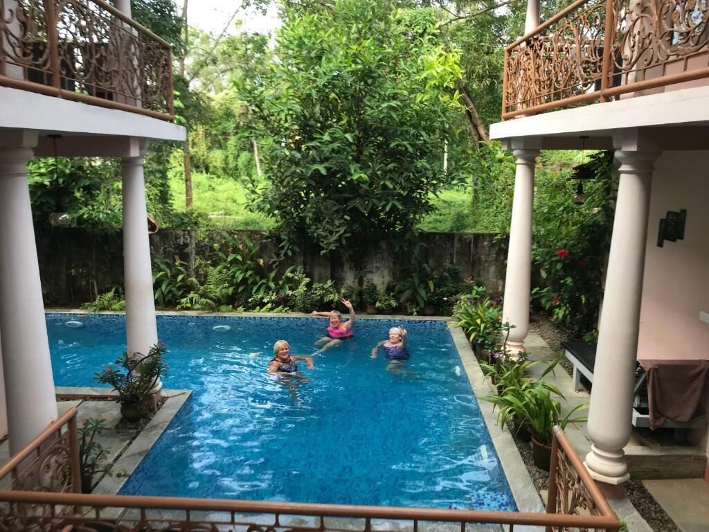 Una piscina al aire libre, sillones reclinables de piscina