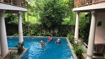 Una piscina al aire libre, sillones reclinables de piscina