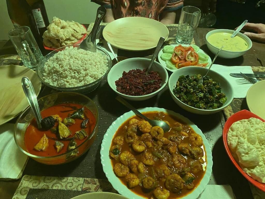 Una mesa con diferentes platos, incluyendo un tazón de arroz, un tazón de sopa y un plato de albóndigas.