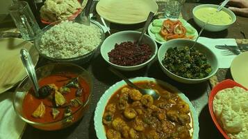 Una mesa con diferentes platos, incluyendo un tazón de arroz, un tazón de sopa y un plato de albóndigas.
