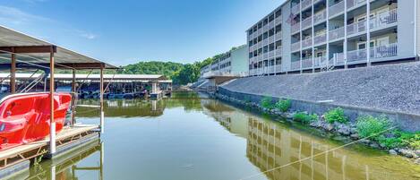 A waterfront hotel with a pool, a covered area, and a building with balconies.