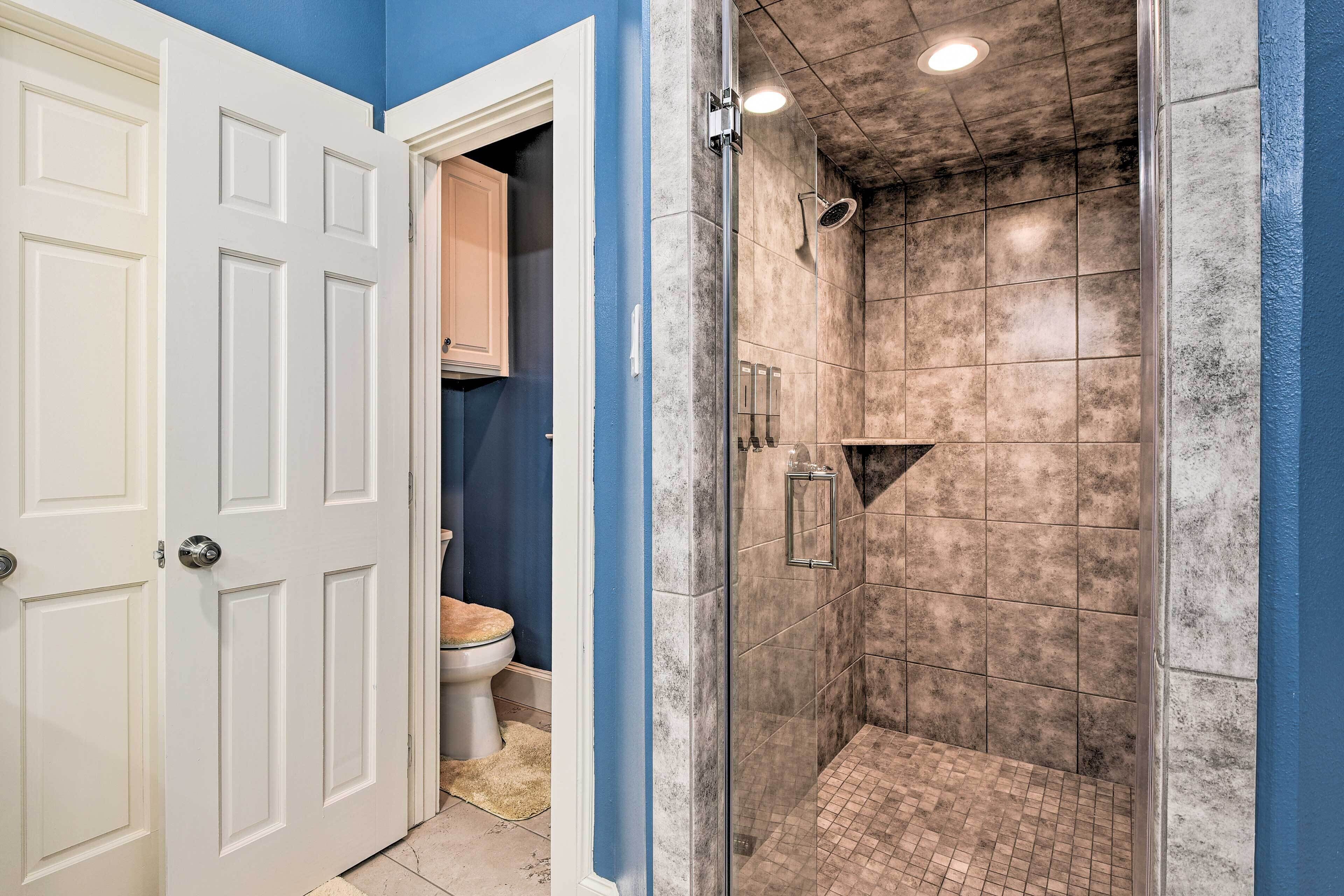 Une salle de bain avec une douche, des toilettes et une porte.
