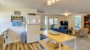 A compact kitchen with a refrigerator, wooden flooring, and a dining area with a table and chairs. - 2 Lamoka Lake Cottages w/ Views, Fire Pit & Dock (Bradford)