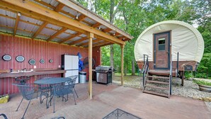 A covered outdoor area with a barbecue grill, metal tables and chairs, a covered dining table, and a large covered wagon. - 50-acre 'pioneers Paradise' 8 Mi to Mammoth Cave! (Brownsville)