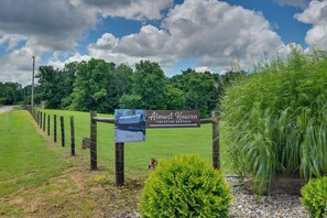 A rural landscape with a sign for 'Almost Heaven Vacation Rentals' and a covered wagon. - 50-acre 'pioneers Paradise' 8 Mi to Mammoth Cave! (Brownsville)