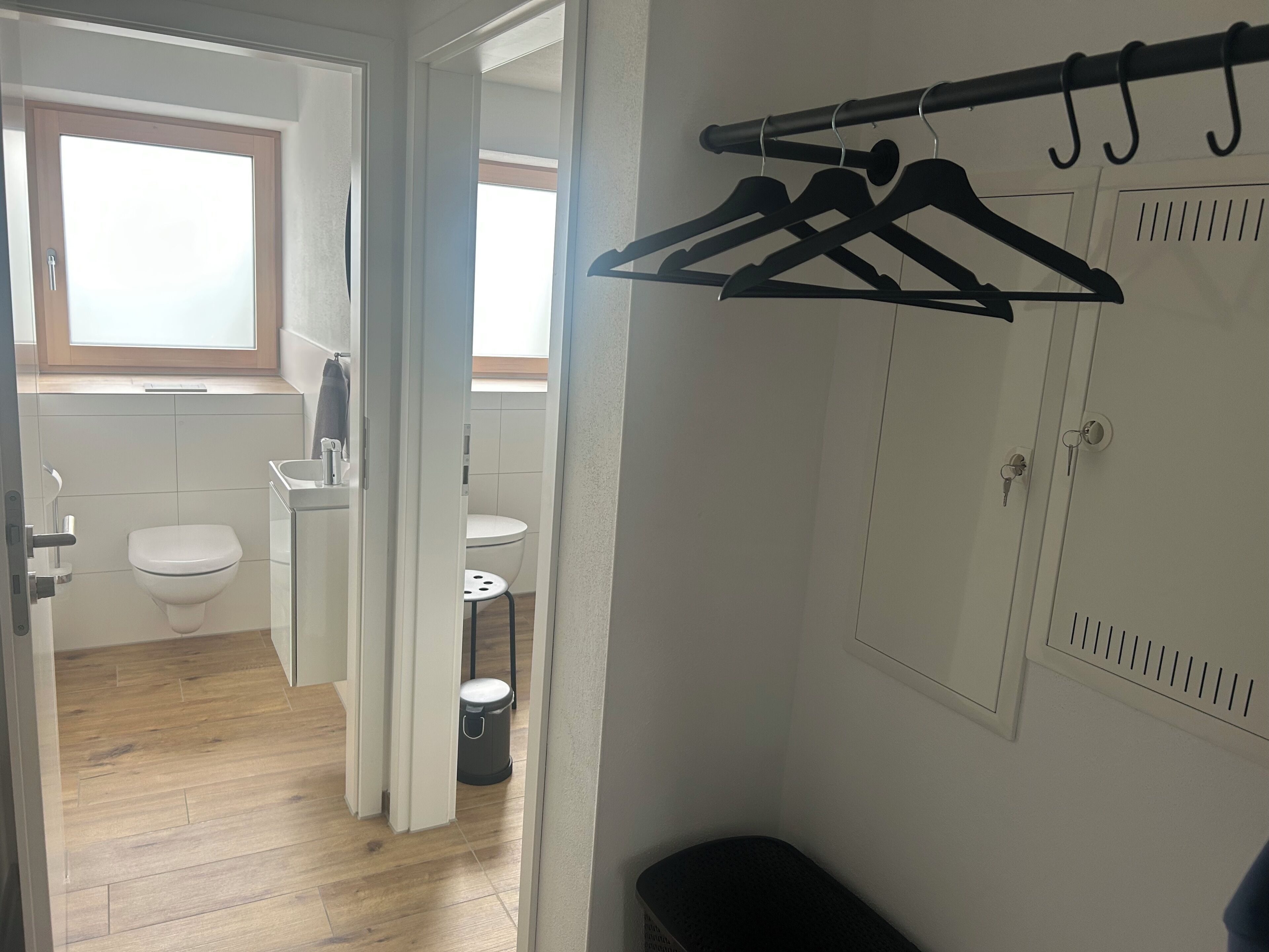 Un baño con inodoro, lavamanos y una ventana pequeña.