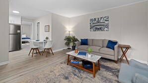 A modern living room with a sofa, coffee table, and dining area. - Tranquil 1-bedroom apartment with AC in vibrant Durham (Durham)