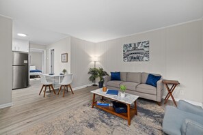 Un salon moderne avec un canapé, une table basse et un coin repas.