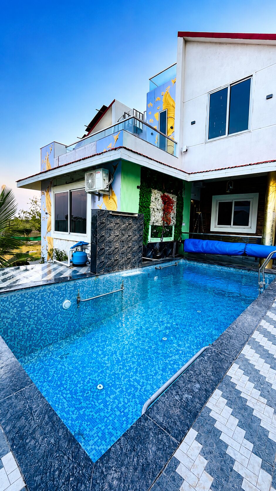 A modern house with a swimming pool, a balcony, and a large window.