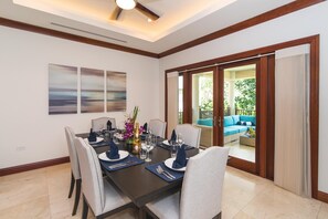 Dining area opens to the veranda with lounge seating. - Casa Luna 4: Gated Luxury Near 7Mile Beach w/Pool, Heated Spa, and Private Beach Cove (Grand Cayman)