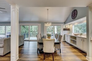 A spacious dining area with a long table, chairs, and a chandelier. - 28 Ruddy Turnstone - Coastal Retreat Near the Beach with Private Pool (Hilton Head Island)