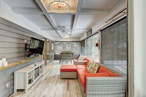 Ein modernes Interieur mit einer Couch, einem Esstisch und einem an der Wand befestigten Fernseher.