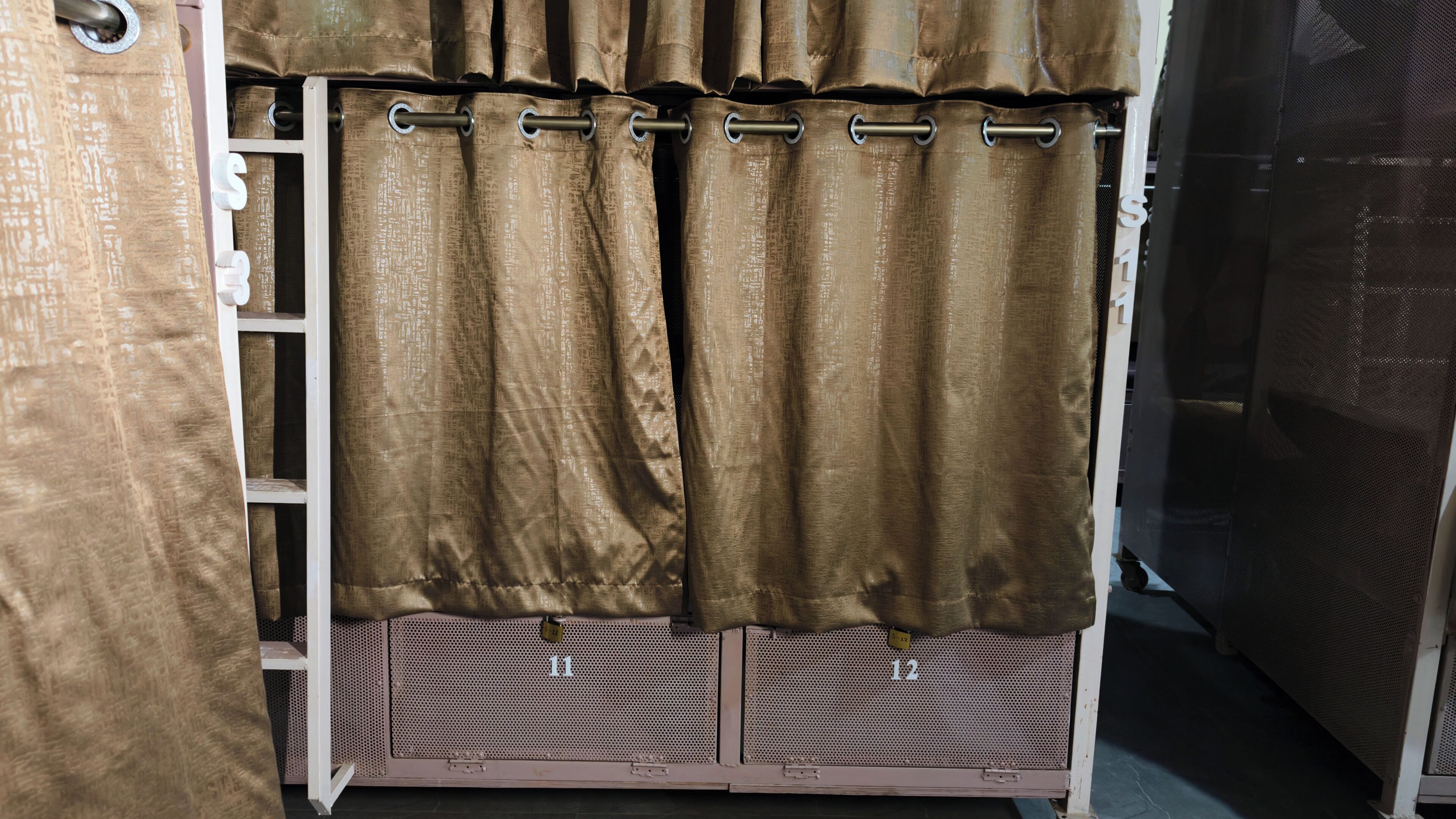 A storage unit with metal shelving and a brown curtain.