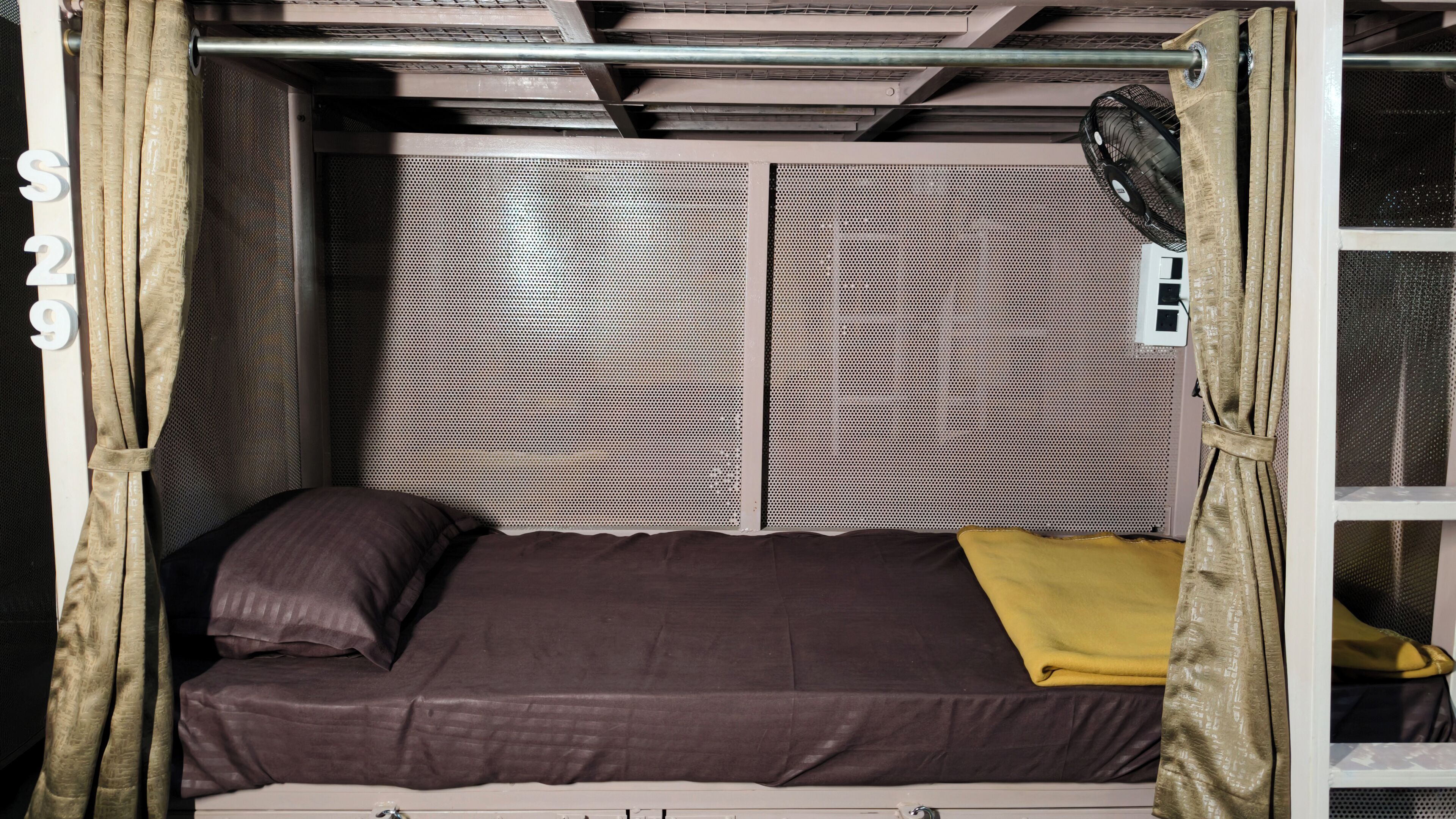 A bunk bed with a headboard, a pillow, and a blanket.