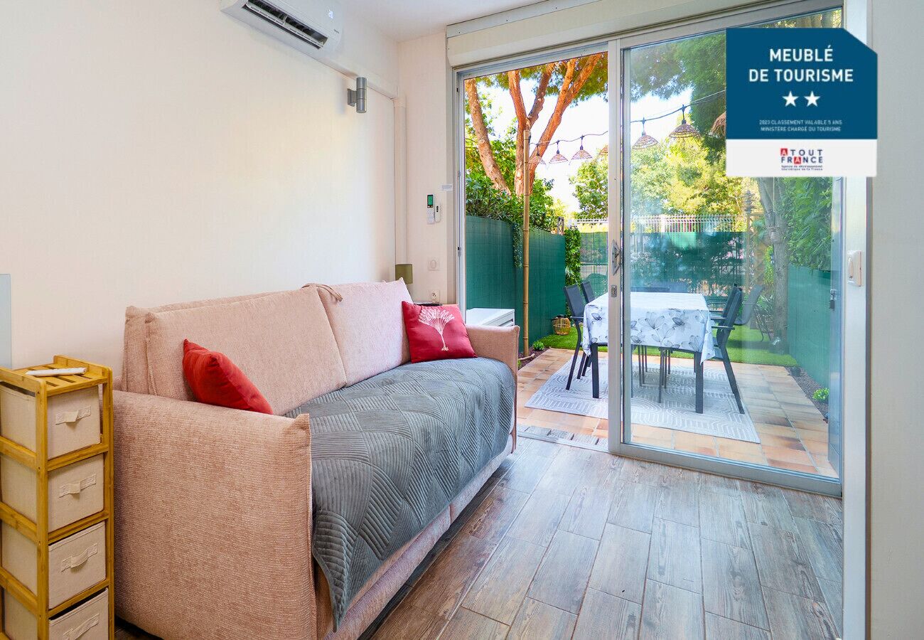 A modern room with a sofa, a small table, and a glass door leading to an outdoor area.