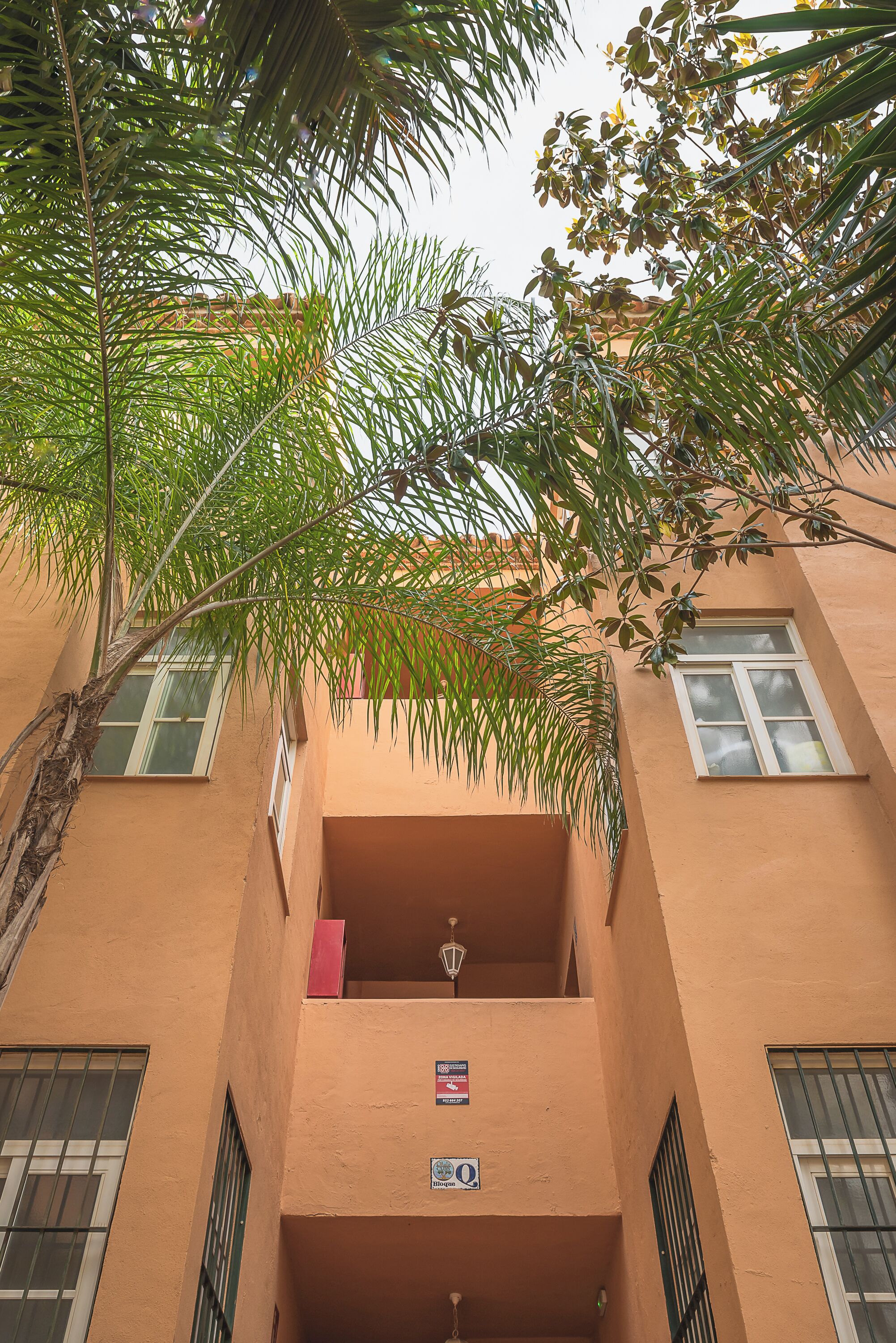 Ein Gebäude mit Balkon, Fenster und einem Schild.