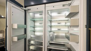 Een moderne keuken met een inbouwkoelkast, oven en magnetron.