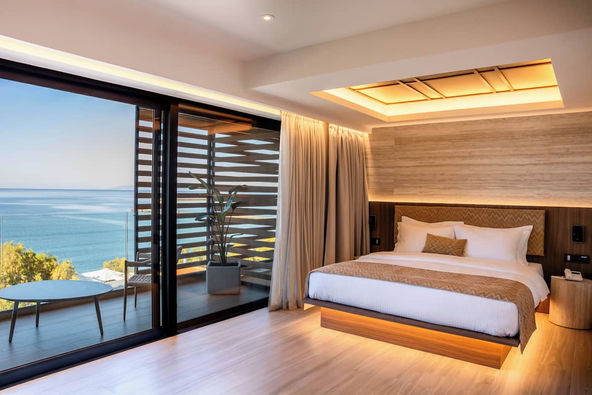 Suite junior, balcón, vista al mar | Minibar, caja de seguridad en la habitación y escritorio