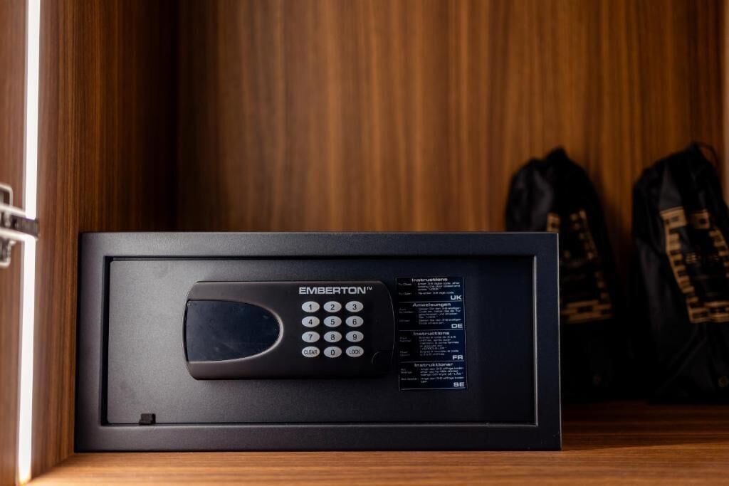 Microondas negro dentro de un gabinete de madera, con un teclado y manual de instrucciones en varios idiomas.
