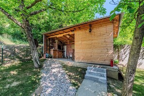 A wooden cabin with a brick fireplace, gravel path, and steps leading to the entrance. - Holiday Home With Pool And Wellness (Sveti Ivan Zelina)
