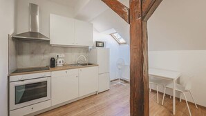 Eine moderne Küche mit weißen Schränken, einer Edelstahl-Dunstabzugshaube und Holzboden.