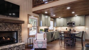 A modern kitchen with stone fireplace, wooden ceiling, and green cabinets. - Thyme Out | Hot Tub | 7 Minutes to Blue Ridge (Blue Ridge)