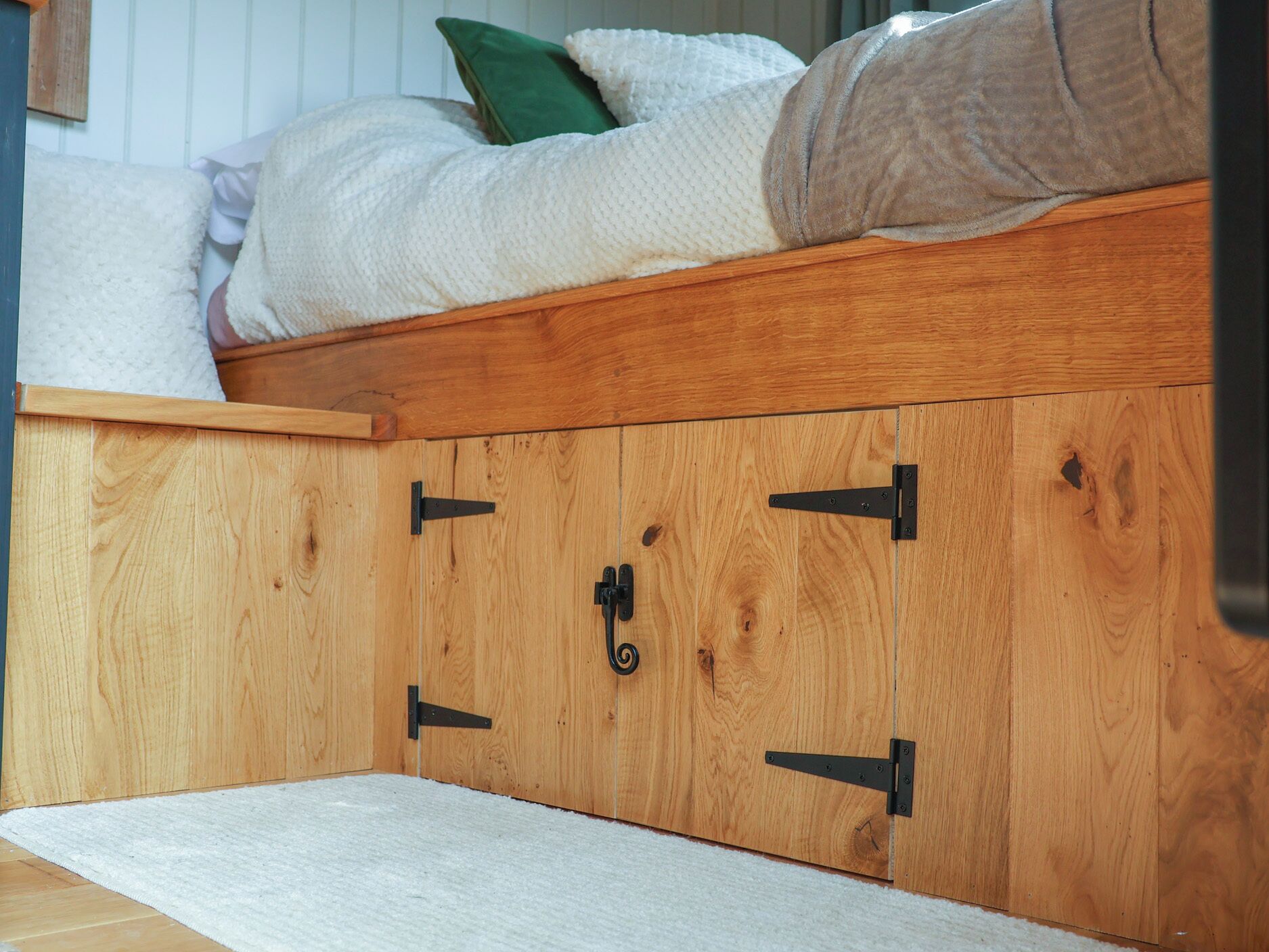 A wooden bed with a storage compartment underneath.