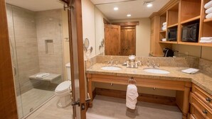 A modern bathroom with a glass-enclosed shower, two sinks, wooden cabinetry, and a large mirror. - One Bedroom Two Queen Suite 1 Suite (Park City)