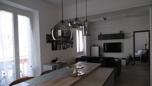 Una cuina moderna amb una illa de fusta, llums penjants i zona de menjador amb cadires.