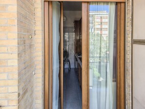 Un corridoio stretto che porta a una cucina con vista su una zona residenziale.