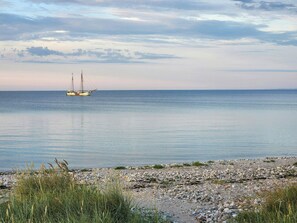 A calm sea with a sailboat anchored in the distance. - Family holiday home on Als with sauna and shelter (Sydals)