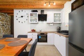 A modern kitchen with white cabinets, a built-in oven, a refrigerator, and a wall clock. - Casa Rosina in Šestani - Haus für 4-5 Personen (Zarecje)