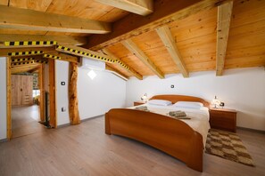 A bedroom with a wooden ceiling, a curved bed, bedside tables, and a stone wall. - Casa Rosina in Šestani - Haus für 4-5 Personen (Zarecje)
