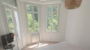 Ein Schlafzimmer mit einem Bett, einem Heizkörper, einem Fernseher und einem Fenster.