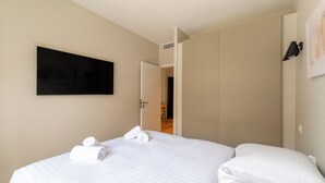 Ein Hotelzimmer mit einem Bett, einem Flachbildfernseher und einer Tür zu einem Badezimmer.