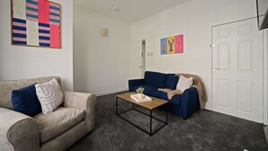 A living room with two sofas, a coffee table, and a door. - Cleethorpes Home Near Beach, Free Parking, Fast (Cleethorpes)