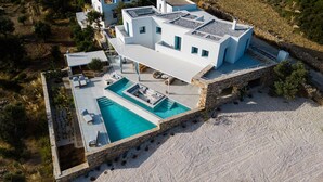Uma villa moderna com piscina, paredes de pedra e terraço no terraço.