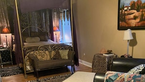 A bedroom with a canopy bed, a chaise lounge, a zebra-patterned rug, and a painting on the wall. - 5 star Super Host, 3-bedroom, one story,  Hottub Grapevine, Lake Access (Grapevine)