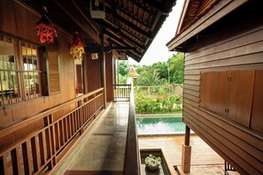 A wooden corridor with a view of a pool and greenery. - Hok Sokol's Villa by Ream Lek (Krong Siem Reap)