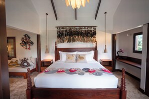 A bedroom with a large bed, wooden headboard, hanging decorations, bedside tables, and a window with a view. - Hok Sokol's Villa by Ream Lek (Krong Siem Reap)