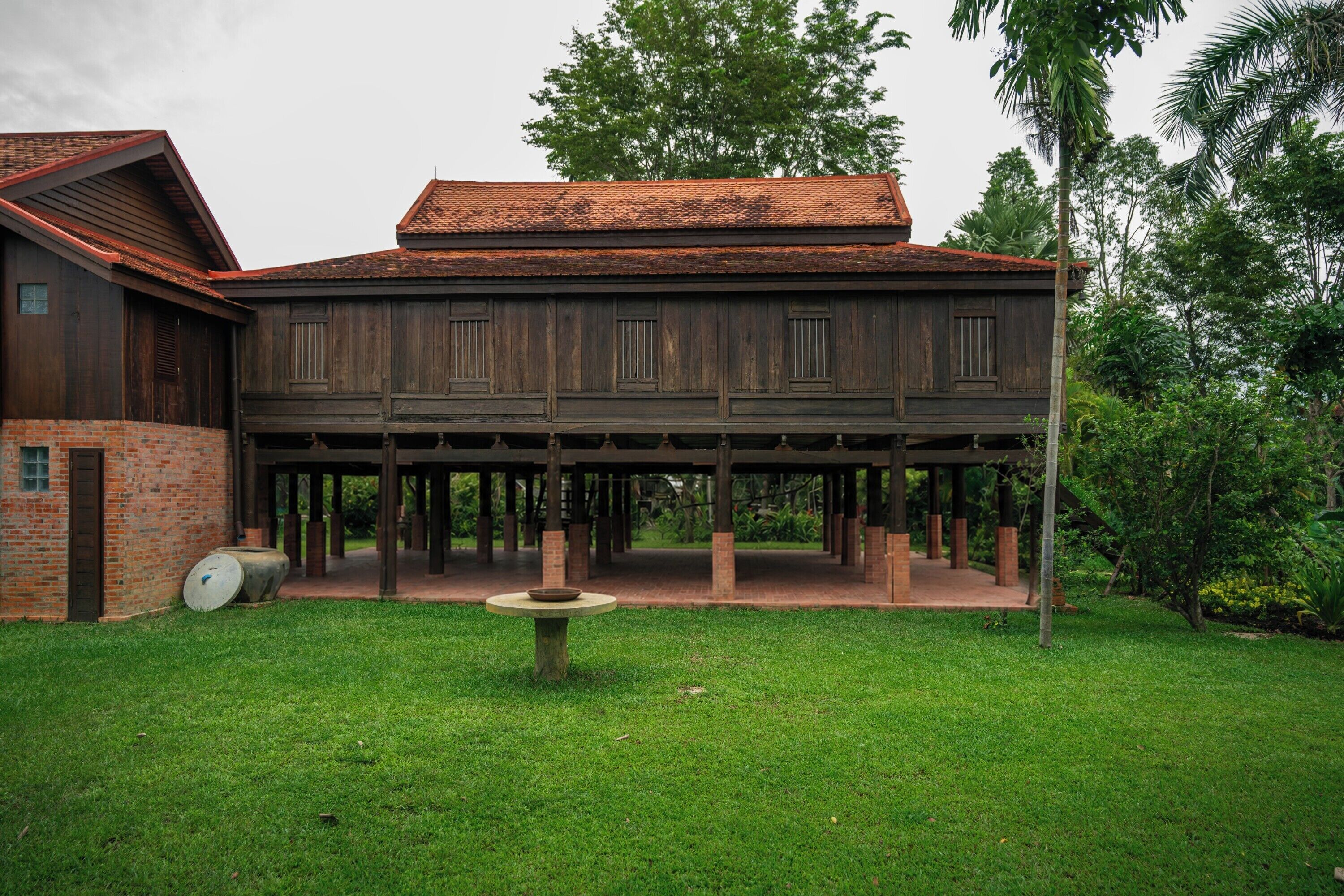A wooden building with a brick foundation and a covered patio area.