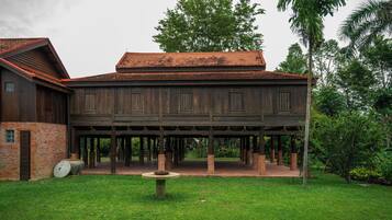 A wooden building with a brick foundation and a covered patio area.