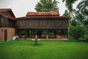 A wooden building with a brick foundation and a covered patio area. - Hok Sokol's Villa by Ream Lek (Krong Siem Reap)
