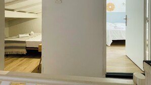 Una stanza con un letto, un tavolino e una presa elettrica.
