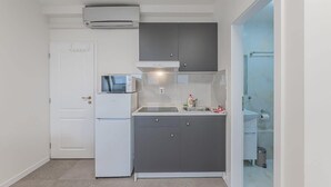 Uma cozinha compacta com geladeira, micro-ondas e pia.