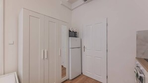 Een kamer met een kast, een koelkast en een deur.